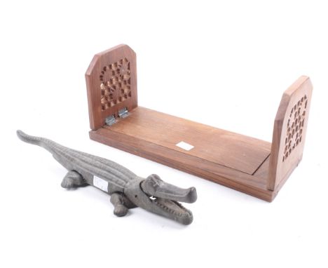 A hardwood book slide and novelty nut cracker. The book slide with carved and pieced decoration, L33.5cm, the metal nutcracke