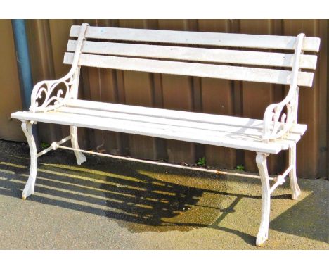 A railway type garden bench, with horizontal slats and wrought iron pierced ends and shaped feet, joined by front to back cyl