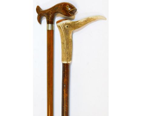 A 20thC walking stick, with carved fish top, plain cylindrical stem, rubber end and metal collar, 89cm H, and another walking