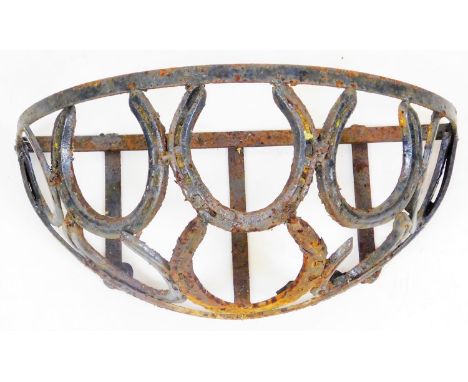 An early 20thC wrought iron planter or feeding trough, of D end form set with horseshoe design, 22cm H, 45cm W, 25cm D. 