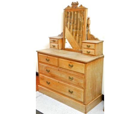 An Edwardian light oak dressing chest, of two short and two long drawers on a block base, with central mirror flanked by two 