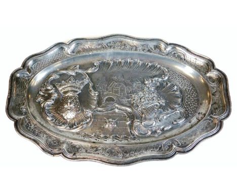 An 18thC French pre-revolution pewter platter, of shaped oval design with scroll, scale and floral border, the centre with re