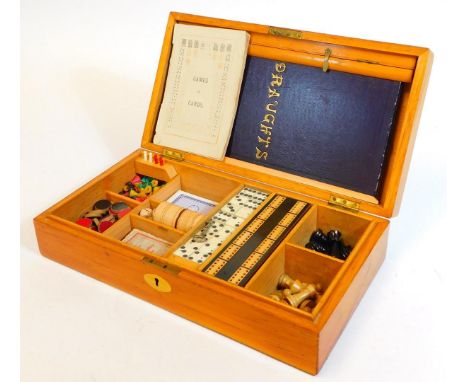 A late 19th/early 20thC games compendium, in a pine case containing dominoes, a cribbage board, chess set, instructions, drau