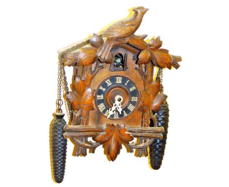 A 20thC Black Forest cuckoo clock, with shaped carved case, 9cm Dia Roman numeric dial and articulated bird movement, with ch