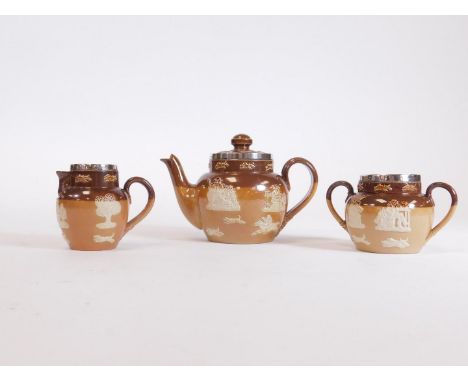 An early 20thC Royal Doulton stoneware three piece miniature tea service, with silver rims, comprising teapot, 10cm H, two ha