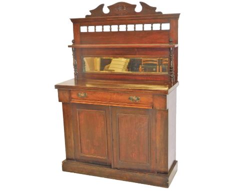 A late Victorian mahogany chiffonier, of small proportion, the carved top raised above an arrangement of urn spindles with a 