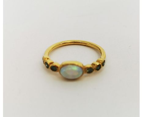 RING, 750er Gelbgold (1,75 g), mittig besetzt mit einem synthetischen Opal und seitlich flankiert von insgesamt 6 grünen Diam