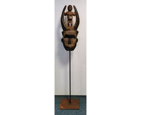 GEHÖRNTE MASKE MIT FIGÜRLICHER BEKRÖNUNG DER BAMBARA, Mali. Holz, geschnitzt, farbig gefasst und teilweise mit Krustenpatina.