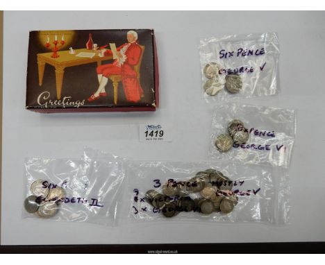 A small quantity of threepenny and sixpenny pieces including George V, VI and Elizabeth II, in a vintage Cadbury Milk Tray bo