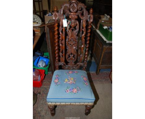An elegant Walnut/Satinwood Hall Chair, the back with twist side supports profusely carved, the pale blue ground tapestry flo