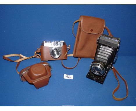 A cased Halina 35 camera and a cased Zeiss Ikon camera.