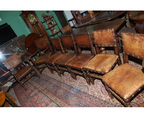 A set of eight robust Oak framed, hide seated and backed Dining Chairs including a pair of carver chairs, standing on turned 