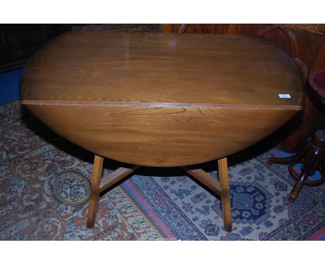 An Ercol dropleaf Dining Table standing on sloping legs united by a cross-stretcher, 44 1/2" x 24" extending to an oval 48 1/