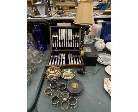 A MIXED LOT TO INCLUDE A VINTAGE CANTEEN OF CUTLERY IN A WOODEN CASE, NAPKIN RINGS, CERAMICS, A TABLE LAMP, MEASURING TAPE, E