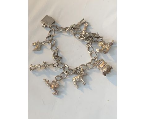 A SILVER CHARM BRACELET WITH TEN CHARMS 