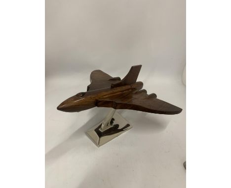 A WOODEN MODEL OF A VULCAN BOMBER ON A CHROME BASE 