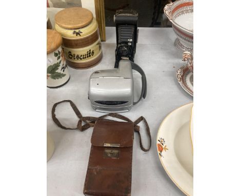 A VINTAGE KODAK CAMERA WITH BELLOWS AND LEATHER CASE AND A POLAROID CAMERA 