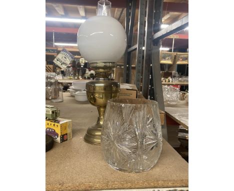 A VINTAGE OIL LAMP WITH BRASS BASE, WHITE SHADE AND GLASS FUNNEL TOGETHER WITH A CRYSTAL VASE 