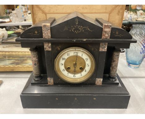 A VINTAGE BLACK MARBLE MANTLE CLOCK WITH PILLAR DECORATION VENDOR STATES IN WORKING ORDER BUT NO WARRANTY GIVEN 
