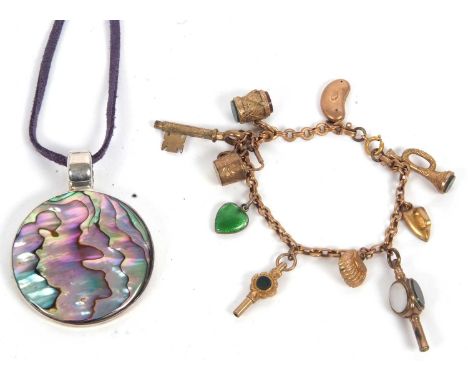 A charm bracelet, with one link stamped 9c, set with a variety of charms, variously marked and unmarked, to include two agate