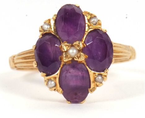 An 18ct amethyst and seed pearl ring, the four oval amethysts set with seed pearls, with reeded shoulders and plain band hall