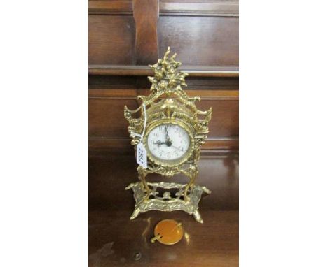 A decorative brass mantel clock with quartz movement.