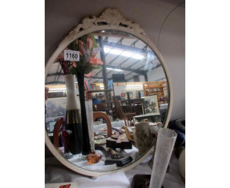 An oval mirror with white surround