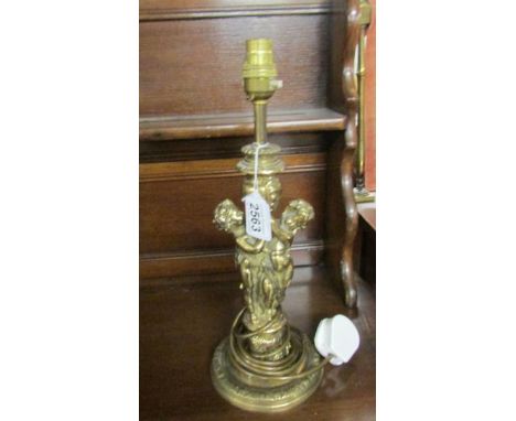 A brass table lamp featuring cherubs.