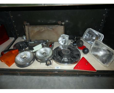 A shelf of vintage/classic car headlights spot lights, Volvo hubcap etc including bicycle lights