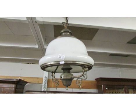A brass hanging ceiling light with opaque glass shade.