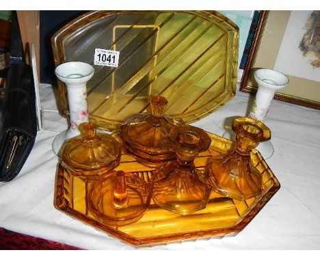 An amber glass trinket set, spare amber glass tray and pair of china candlesticks.