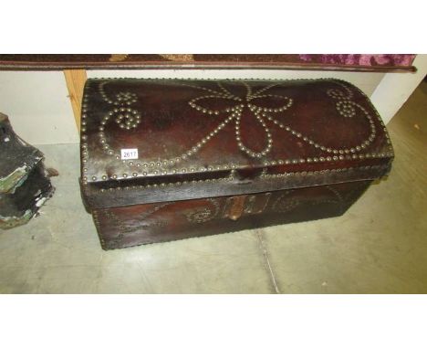 A late 18th century domed top trunk with leather covering and brass pin decoration.