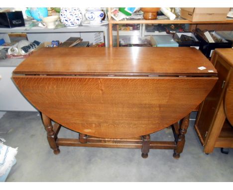 A 1930's oak gate leg table height 75cm, closed 113cm x 40cm, open 113cm x 134cm