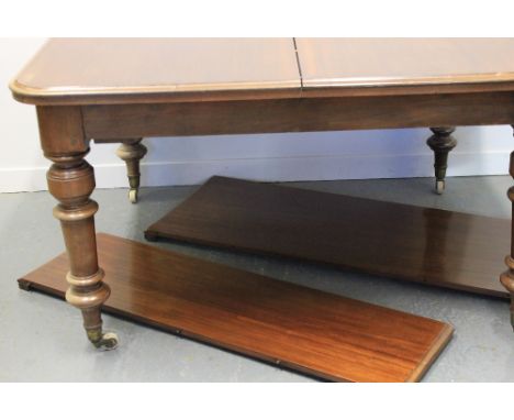 VICTORIAN MAHOGANY EXTENDING DINING TABLE, having moulded edged top with curved angles, standing on squared baluster and ring