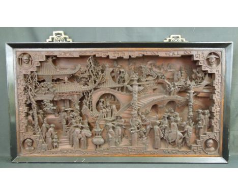 LARGE CHINESE CARVED WOODEN WALL PANEL, deeply and well carved with many figures and architectural features within geometrica