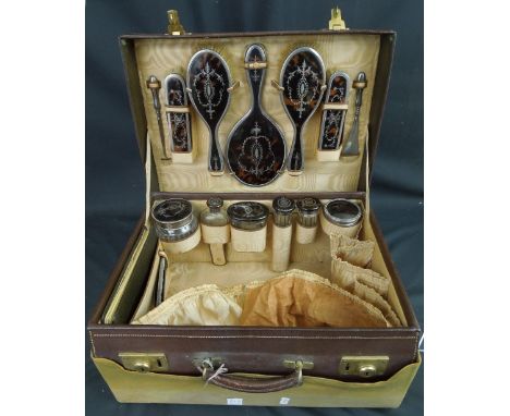 EARLY 19TH CENTURY LEATHER TRAVELLING VANITY SUITCASE, having canvas cover initialled: M.P.H. and containing assorted silver 