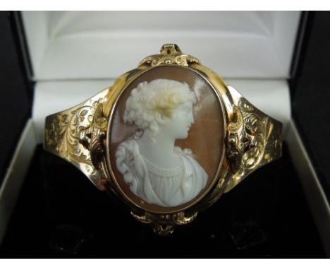 20TH CENTURY GOLD CAMEO BANGLE with Grecian figure and foliate engraved shoulders to the hinged bracelet.  Unmarked.  The Cam