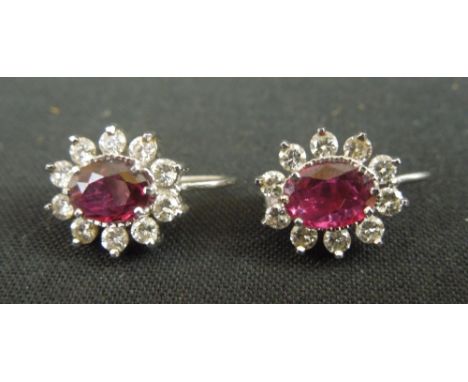 A PAIR OF OVAL RUBY AND DIAMOND EARRINGS.  The oval ruby measuring approximately 7 x 5mm, surrounded by ten brilliant cut dia