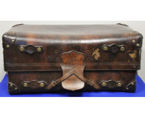 LATE 19TH/EARLY 20TH CENTURY HEAVY LEATHER TRAVELLING TRUNK with brass studded, reinforced corners, pulled scroll decoration,