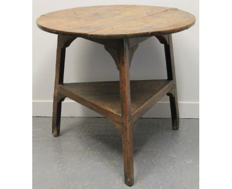 19TH CENTURY TRADITIONAL WELSH OAK CRICKET TABLE, having planked circular top over triangular under shelf on three square leg