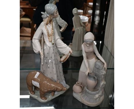 A Lladro figure, gipsy girl with performing bear, 38 cm to/w a Nao bisque figure of a girl at a well-fountain, 30 cm (2)Chip 