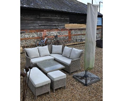 A weathered Bramblecrest rattan L-shaped sofa with weatherproof cushions to/with a metamorphic table, a double bench seat and