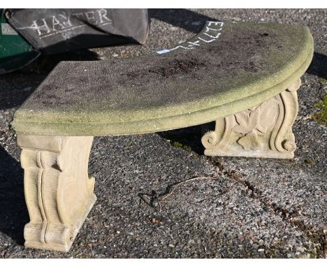 A weathered three piece cast stone garden bench