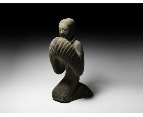 Han Dynasty, 206 BC-220 AD. A ceramic female figure modelled kneeling, hands held within voluminous sleeves in front of the t