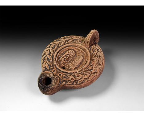 175-225 AD. A terracotta ring-handle lamp, row of chevrons on the spine in shape of a myrtle-wreath imitating a laurel crown,