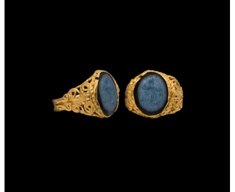 3rd century AD. A gold ring with flat-section hoop with ropework borders and ribbing; expanding shoulders with openwork scrol