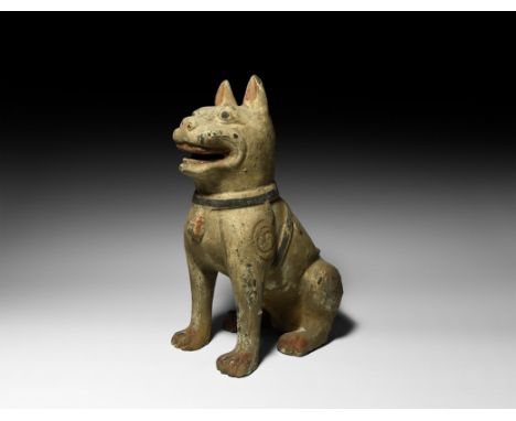 Han Dynasty, 206 BC-220 AD. A hollow-formed ceramic dog modelled sitting; wearing jewelled harness and collar; swirl motifs o