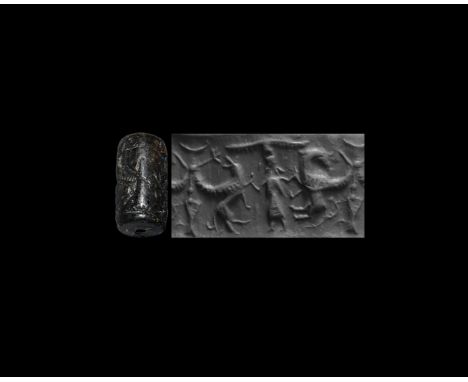 13th-10th century BC. A black limestone cylinder seal, drilled vertically for suspension; accompanied by a museum-quality imp