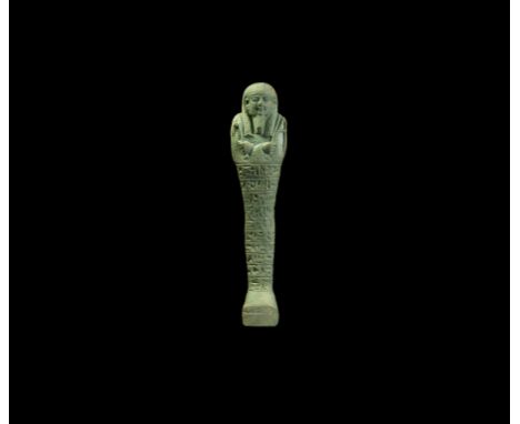 Late Period, 664-332 BC. A glazed composition shabti with tripartite wig and false beard, hand-tools in the crossed hands and