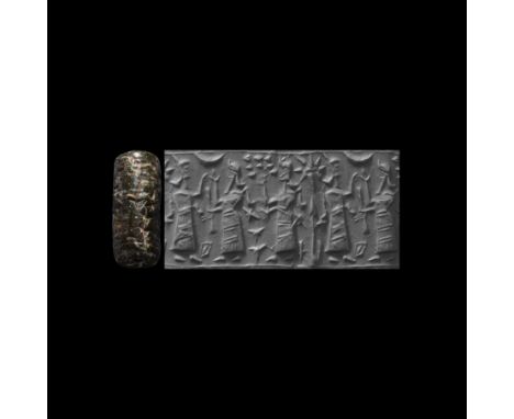 900-750 BC. A carved fossiliferous limestone cylinder seal with a worshipping scene; accompanied by a museum-quality impressi